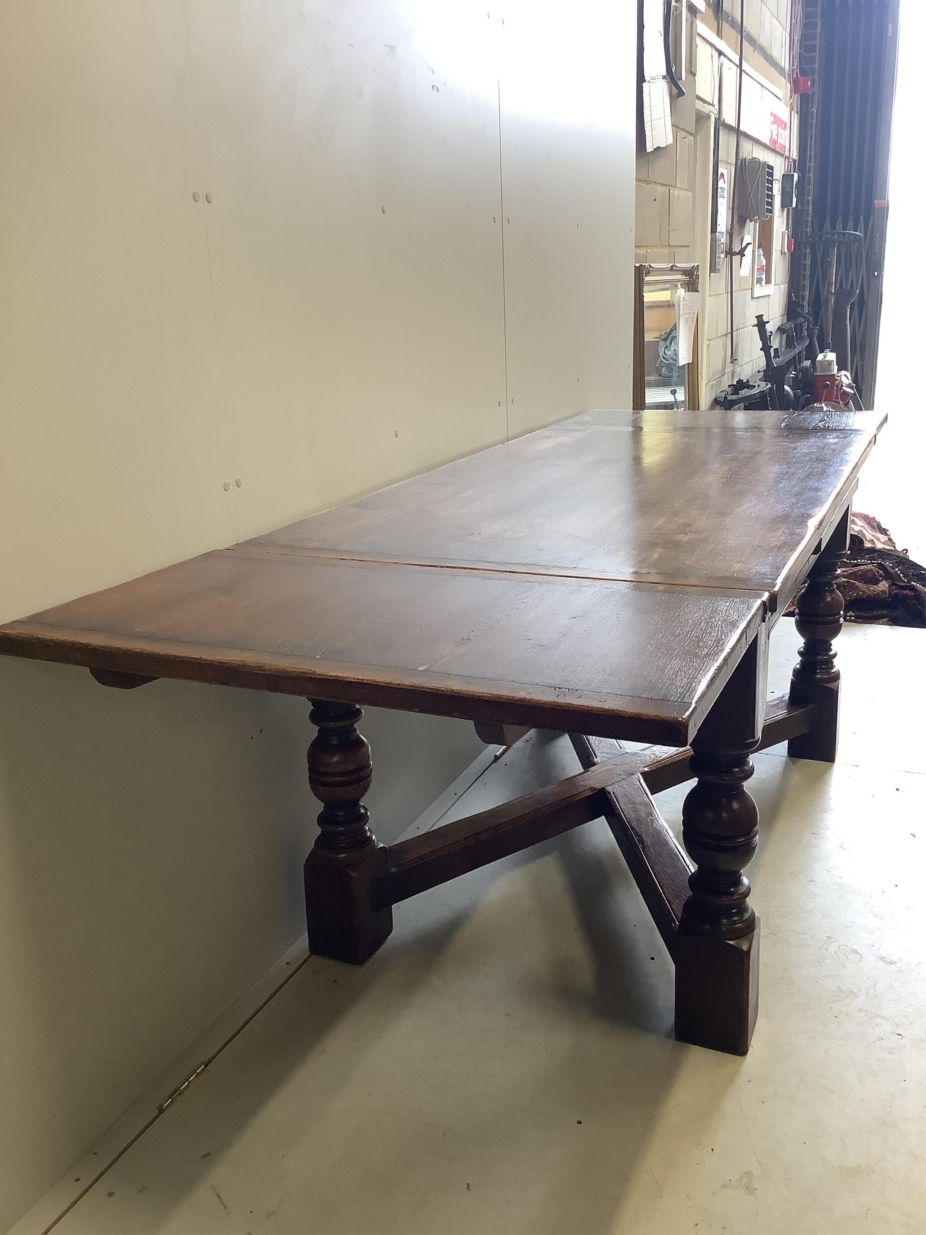 An 18th century style rectangular oak draw leaf refectory dining table, width 244cm extended, depth 85cm, height 79cm together with seven caned oak dining chairs, two with arms. Condition - fair to good